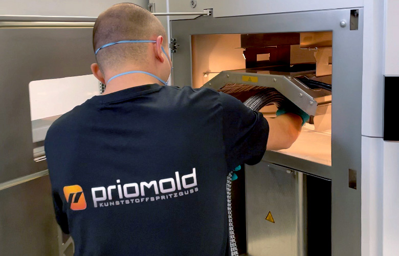 priomold Mitarbeiter arbeitet an einer SLS 3D-Druck Anlage